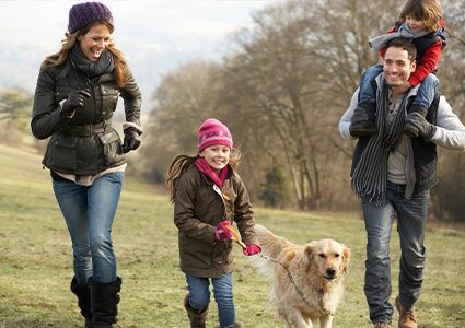 Family walking a dog in the countryside