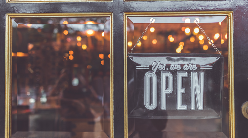 Store-front with 'open' sign displayed on glass entrance door to support brick-and-mortar stores article