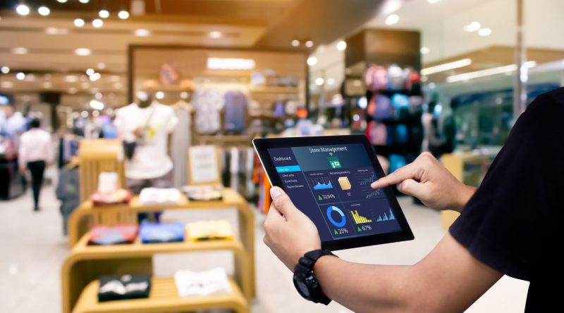 A person using a tablet in a retail store analyzes data illustrating the power of retail data analytics in optimizing store operations and personalizing customer experiences.