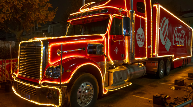 Illuminated Coca-Cola holiday truck with bright festive lights, a classic example of iconic holiday advertising campaigns.