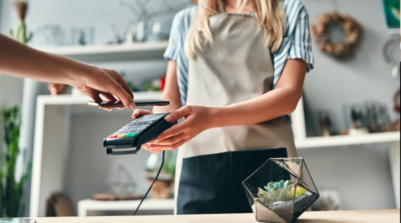 Retail transaction showcasing Wholesalers vs. Retailers, with a customer making a contactless payment.