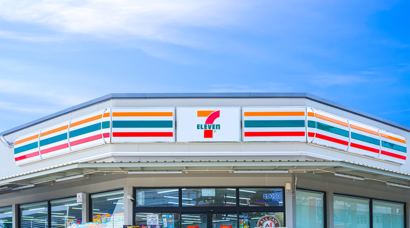 7-Eleven storefront exterior with branded signage and glass entrance, representing convenience retail amid planned store closures