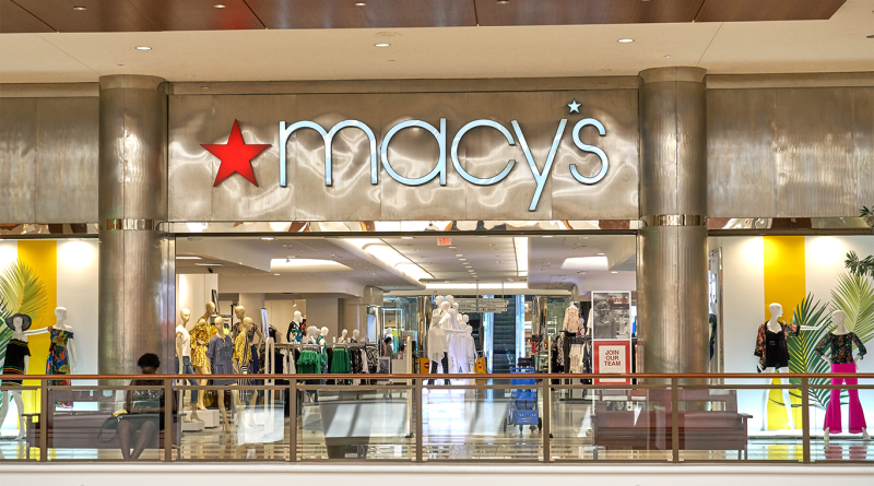 Macy’s department store entrance inside a shopping mall with mannequins, clothing displays and the brand’s red star logo above the storefront