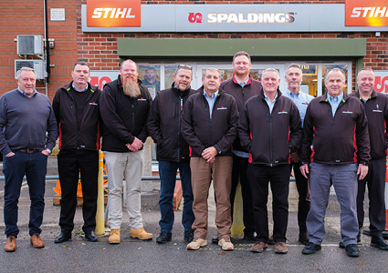 This image shows a group of employees standing outside a store branded with Stihl