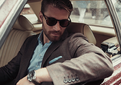 a man is leaning out of the open window of a vintage car, looking down