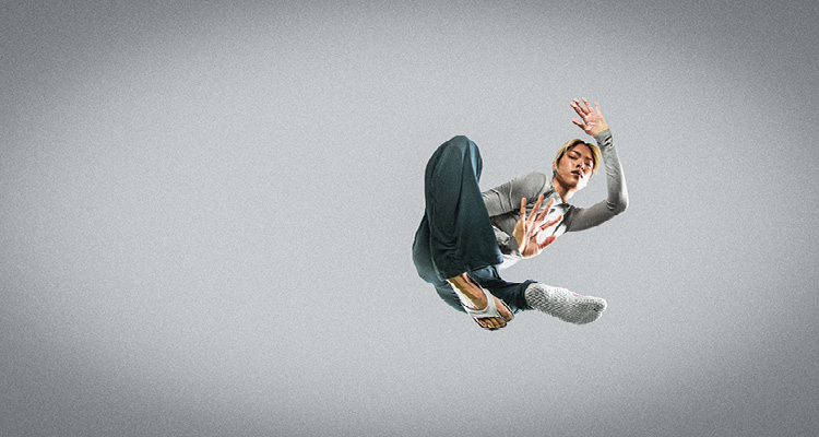 a person in a dynamic jumping pose against a neutral background