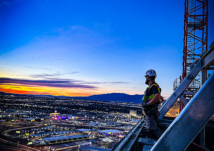 a massive central canopy section being lifted by a large crane at night
