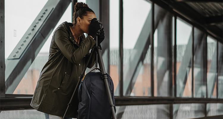 a photographer using a Peak Design Travel Tripod